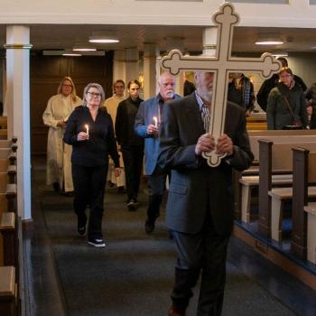 Tekstinlukijat Irina Ojala-Sirro ja Petri Känkänen seuraavat ristiä.